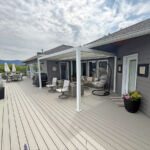 Large second-story wood deck stained to match a New England-gray color scheme
